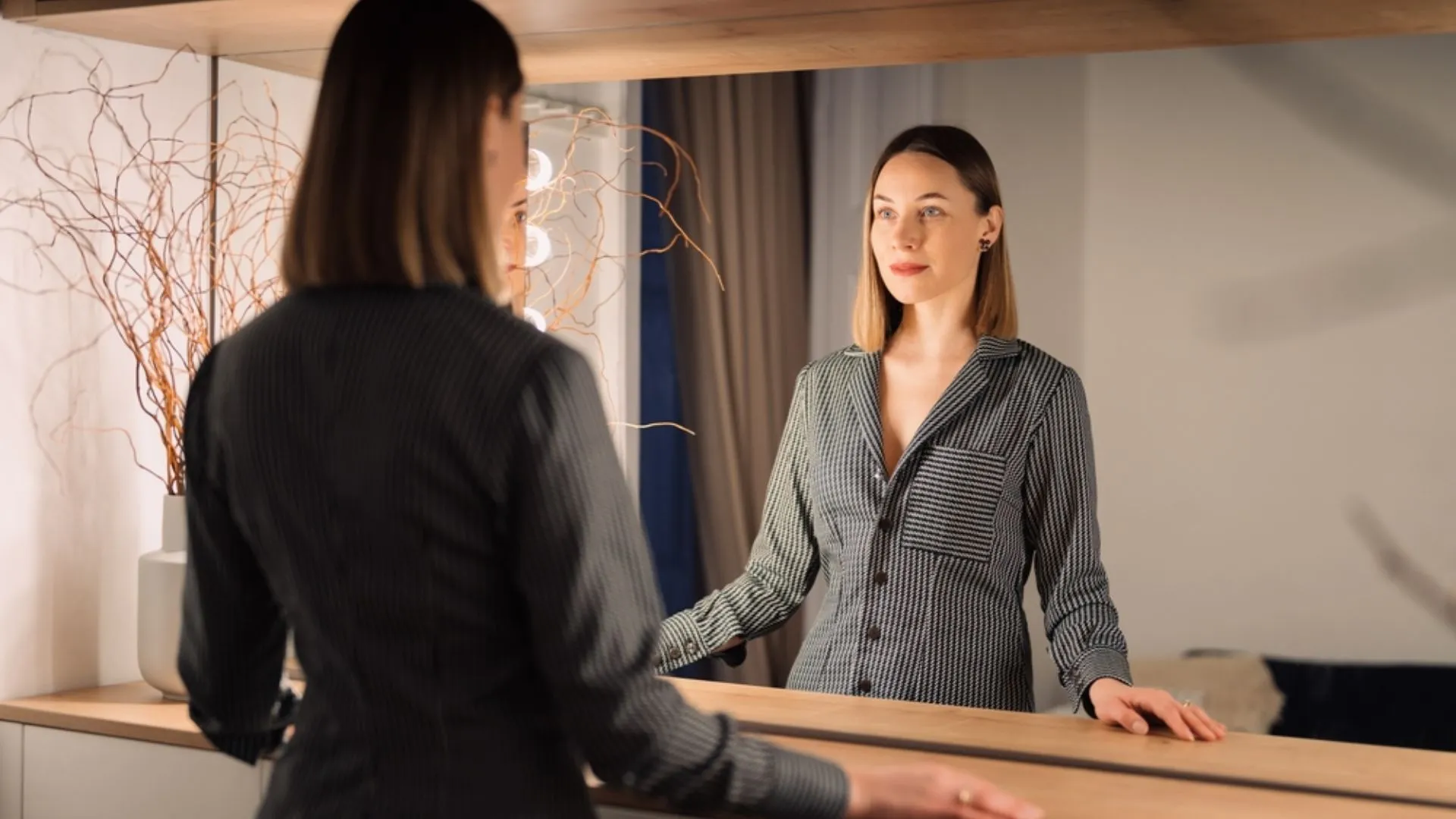 Woman looking in the mirror, reflecting and thinking