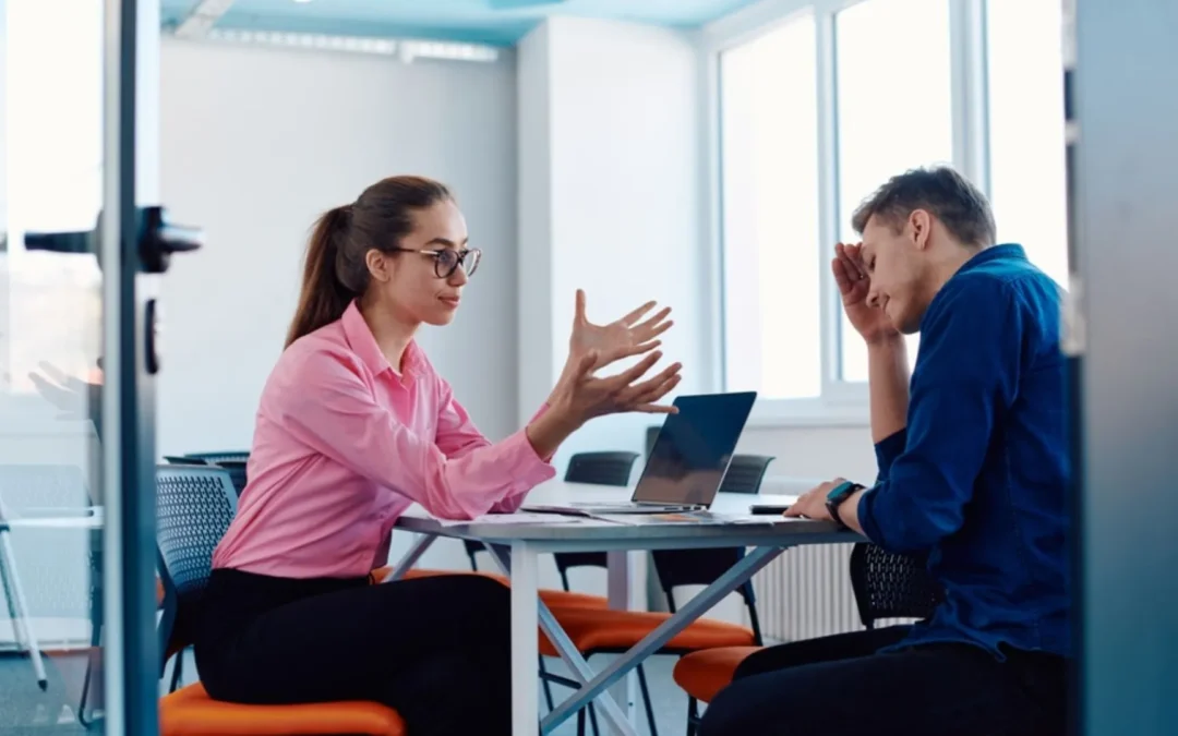 Looking into a meeting room where a manager is talking to an upset employee