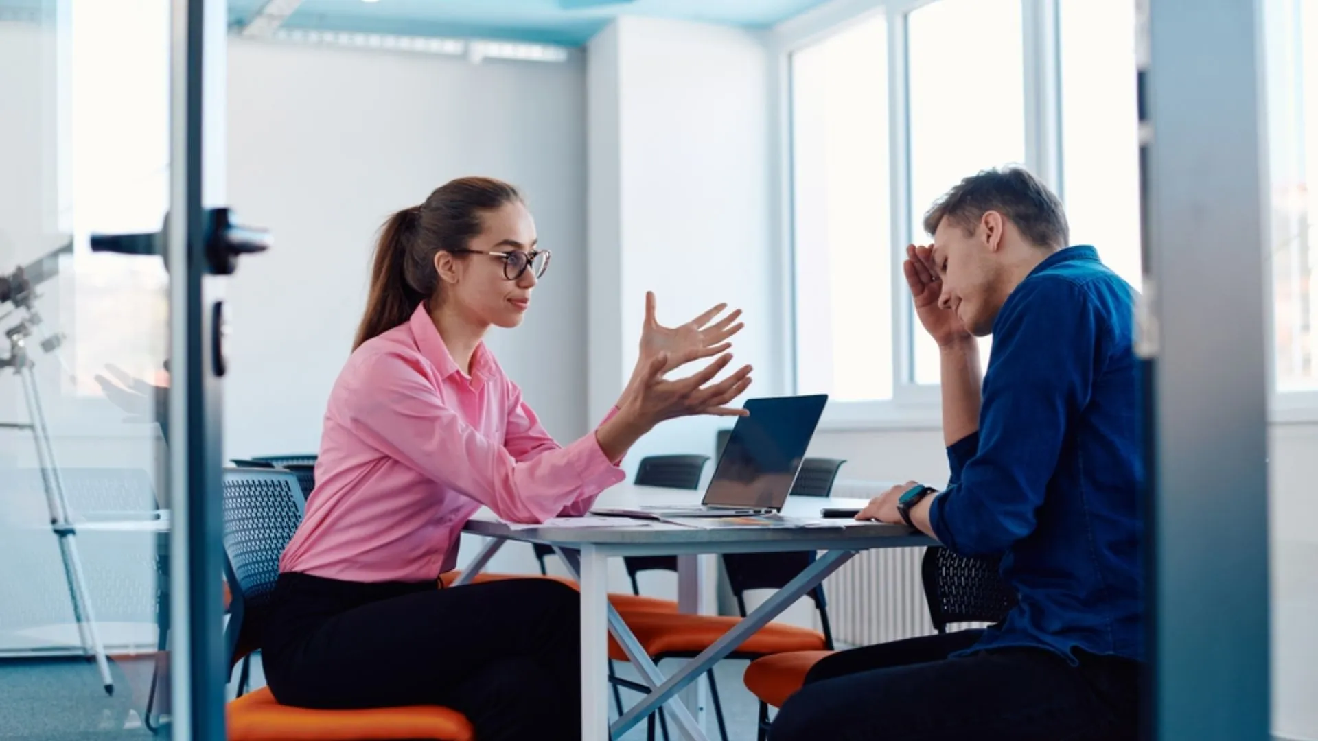 Looking into a meeting room where a manager is talking to an upset employee