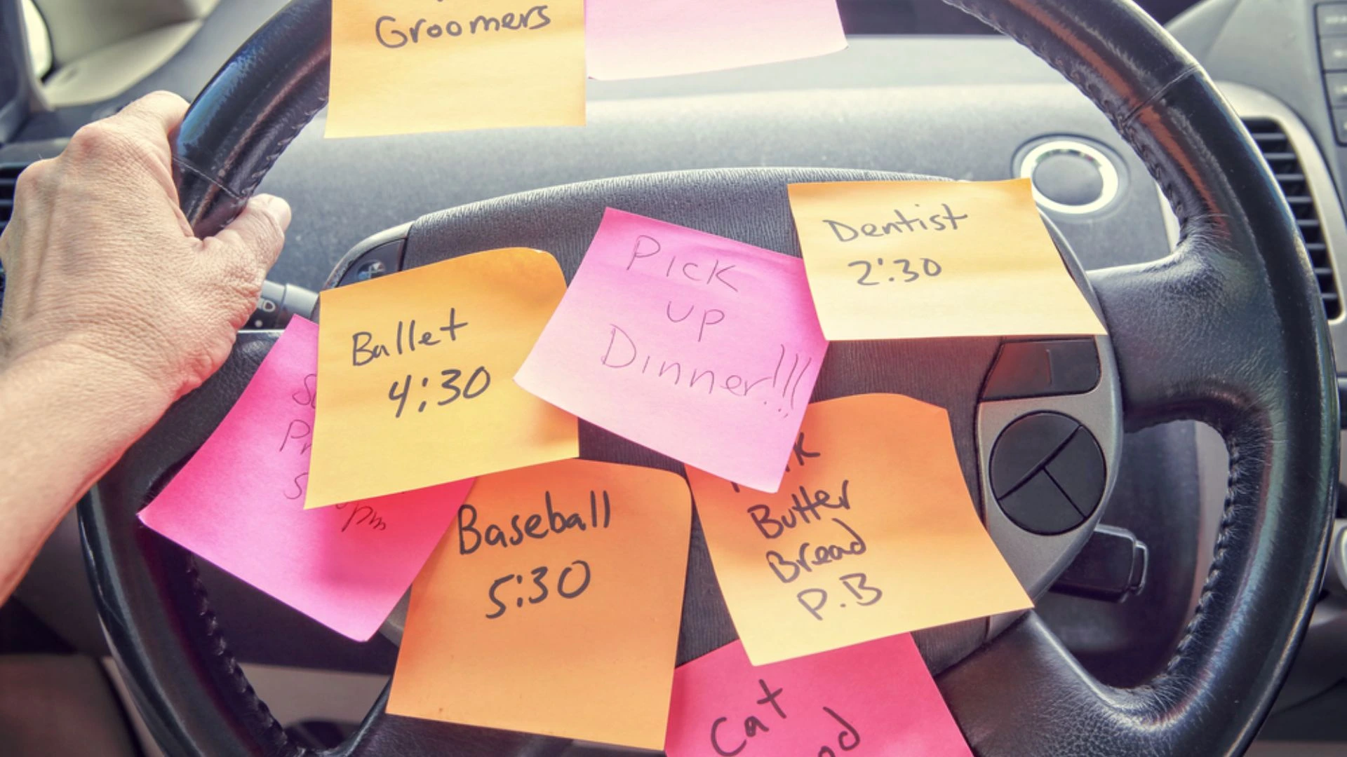 Steering wheel covered in post it notes with tasks