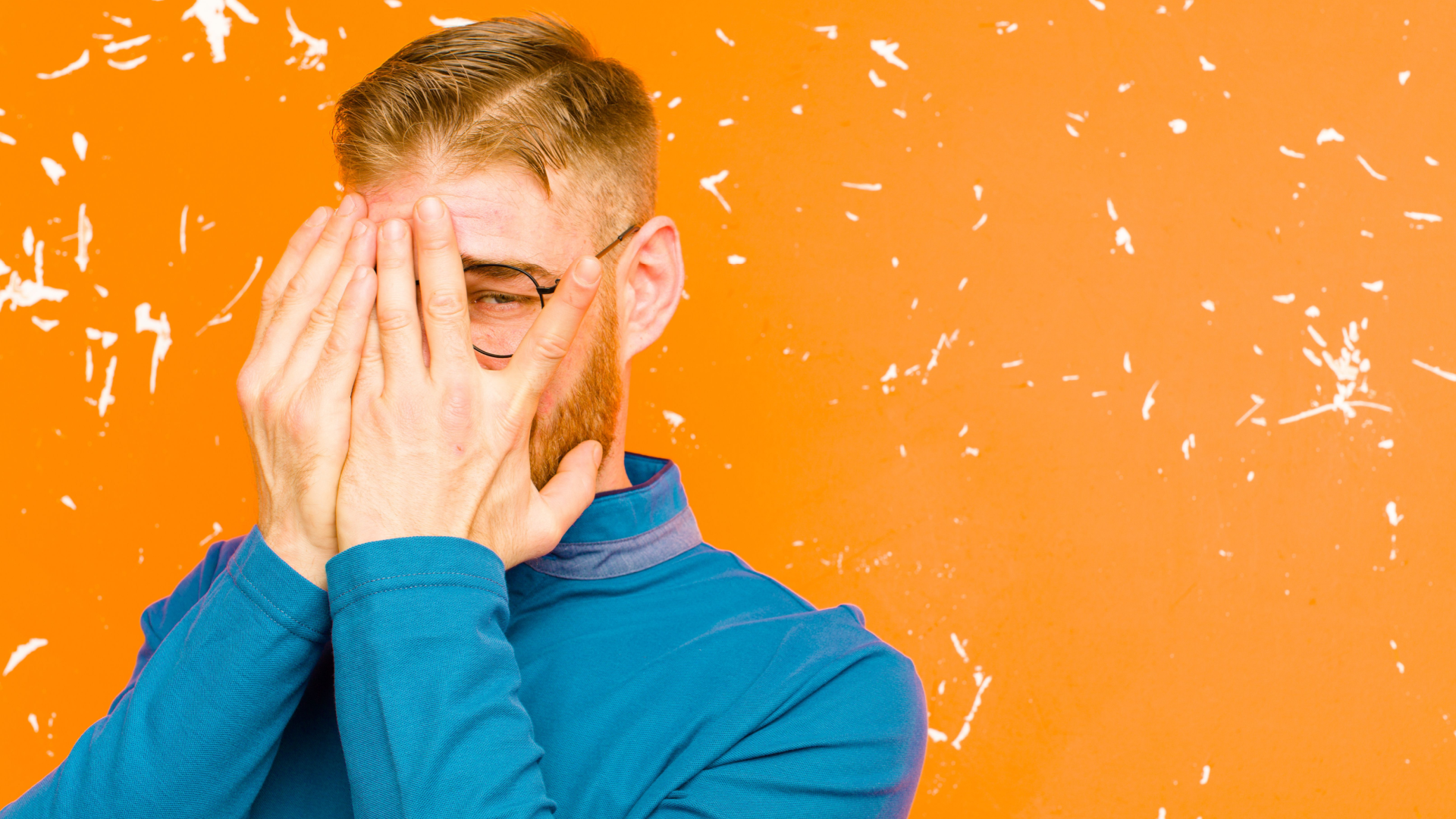 Man peaking out through his fingers