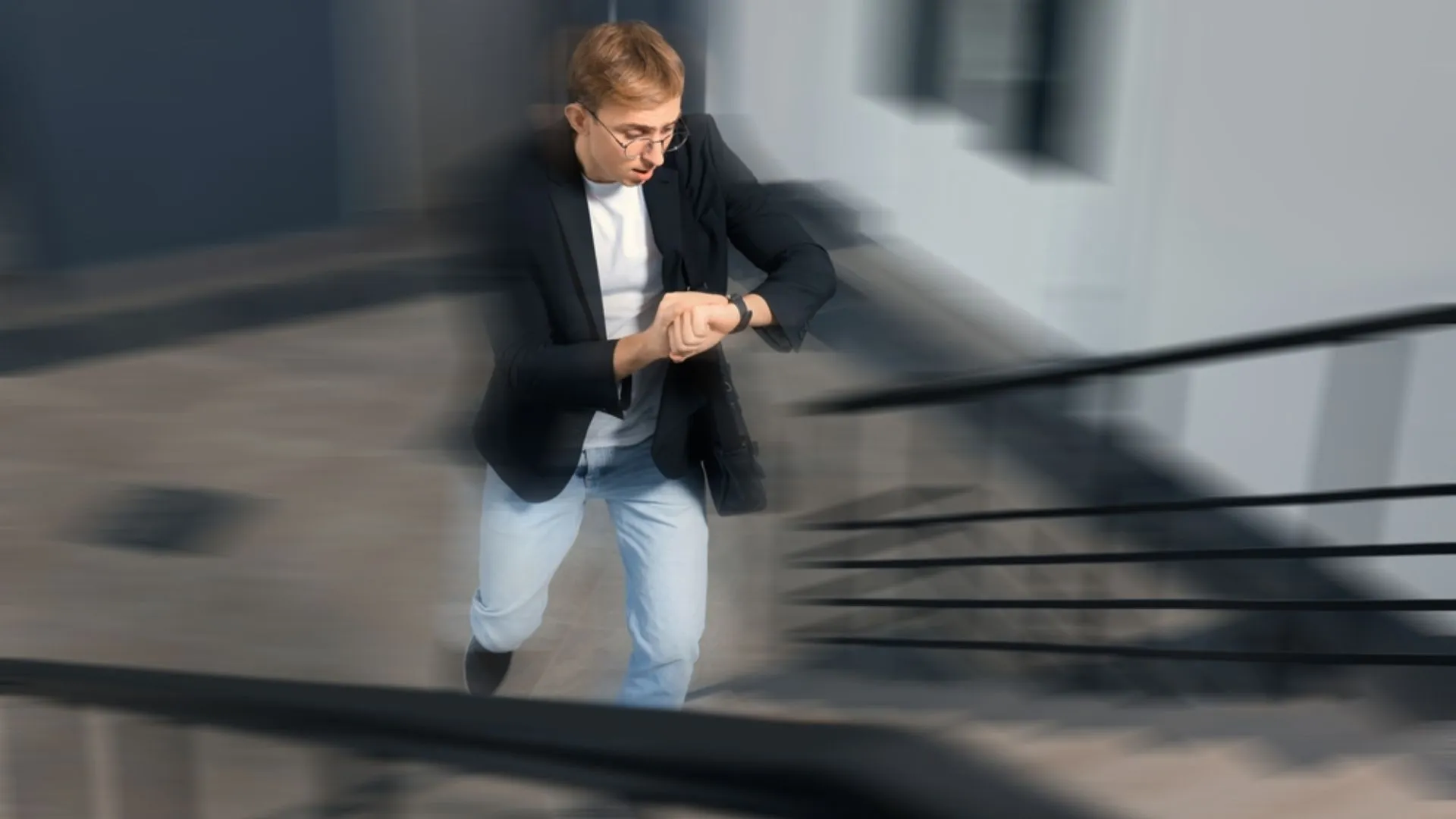 Man looking at watch and rushing up the stairs (background is blurred)